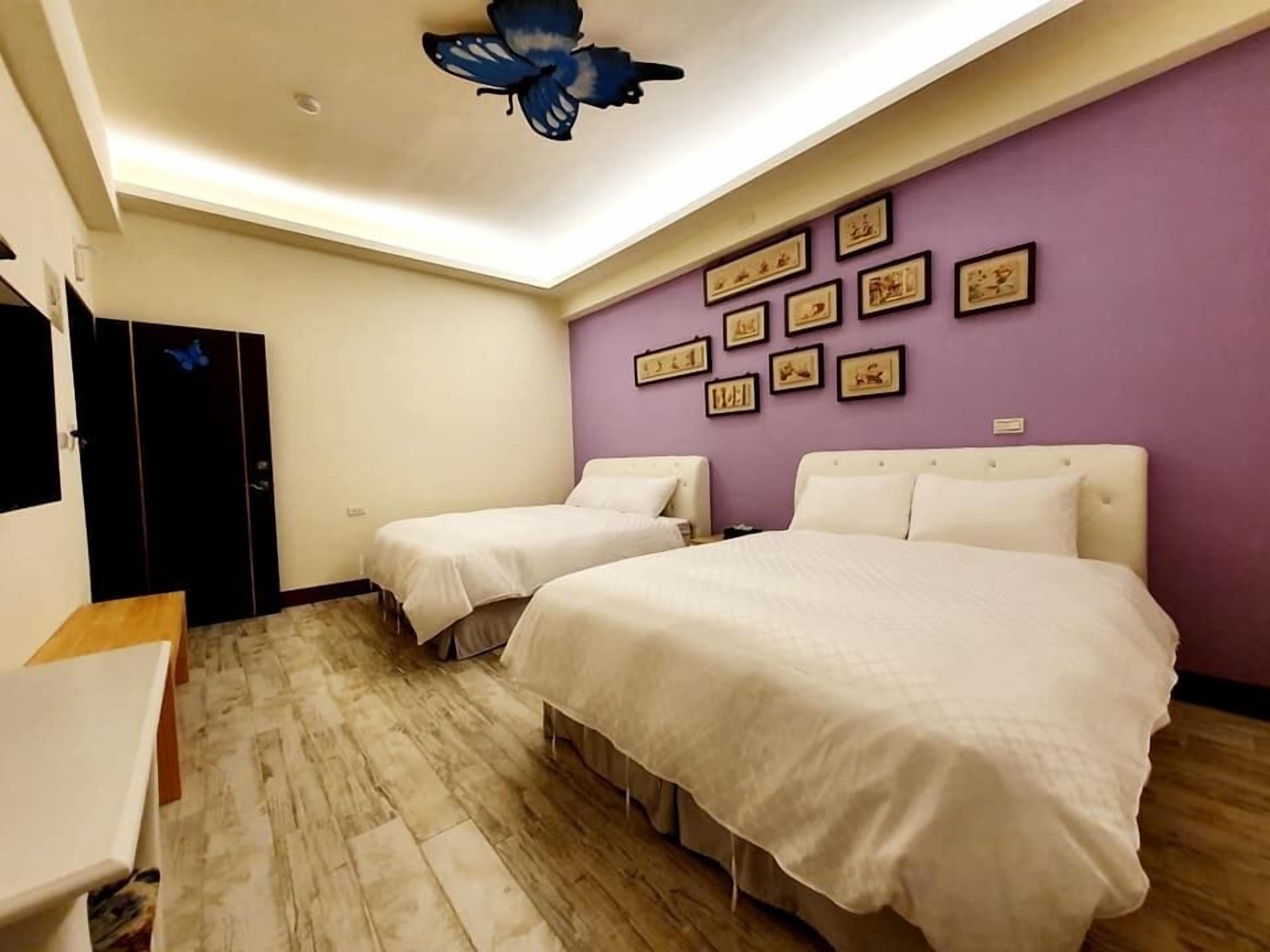 A room with two beds, a desk, and a wardrobe.