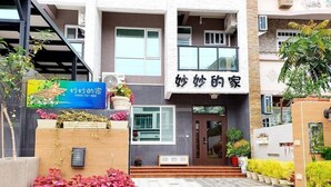 A two-story building with a sign that reads "Shower House". There are potted plants and a staircase leading to the entrance. - Miao Miao de jia (Taitung)