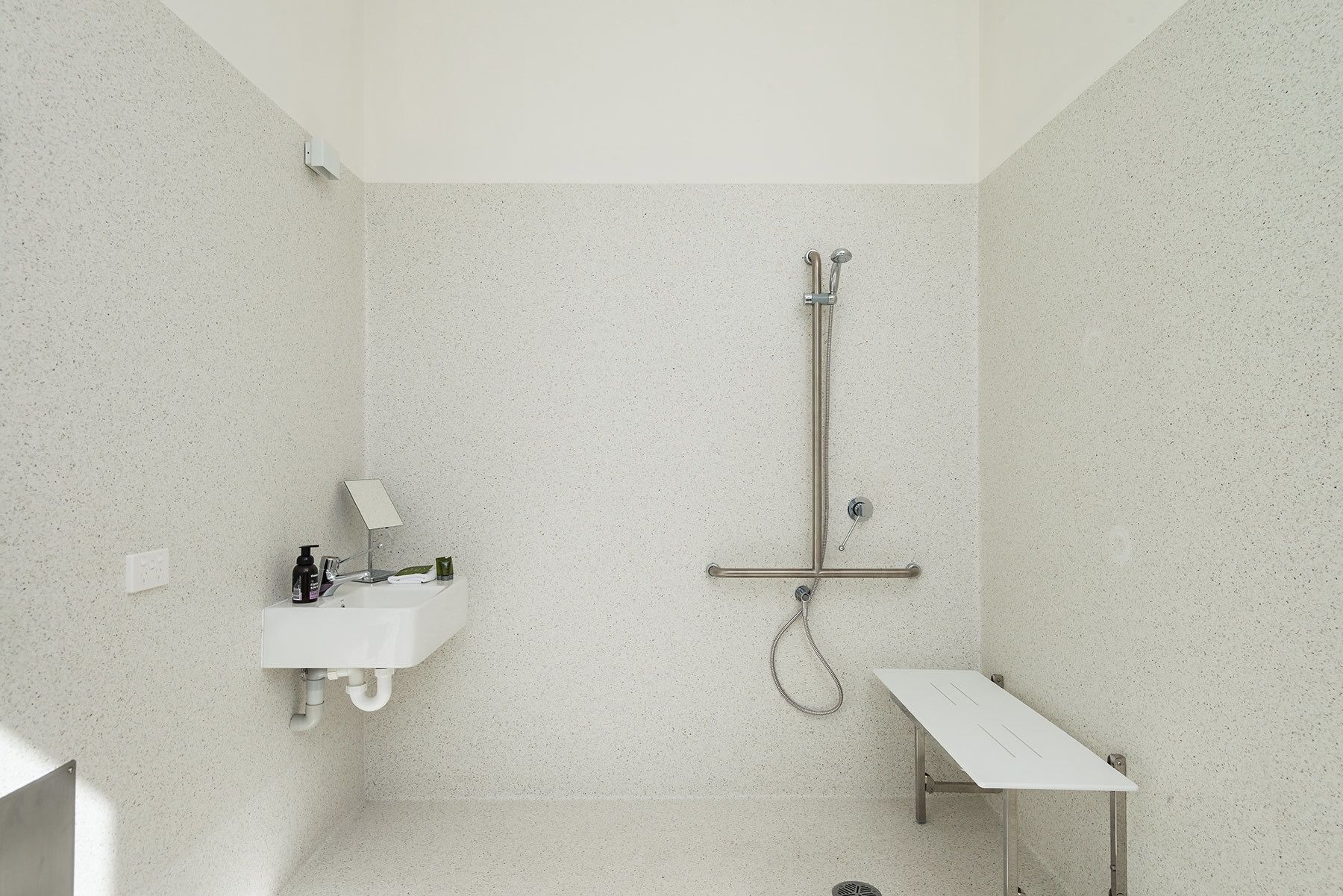 A bathroom with a shower, a sink, and a mirror.