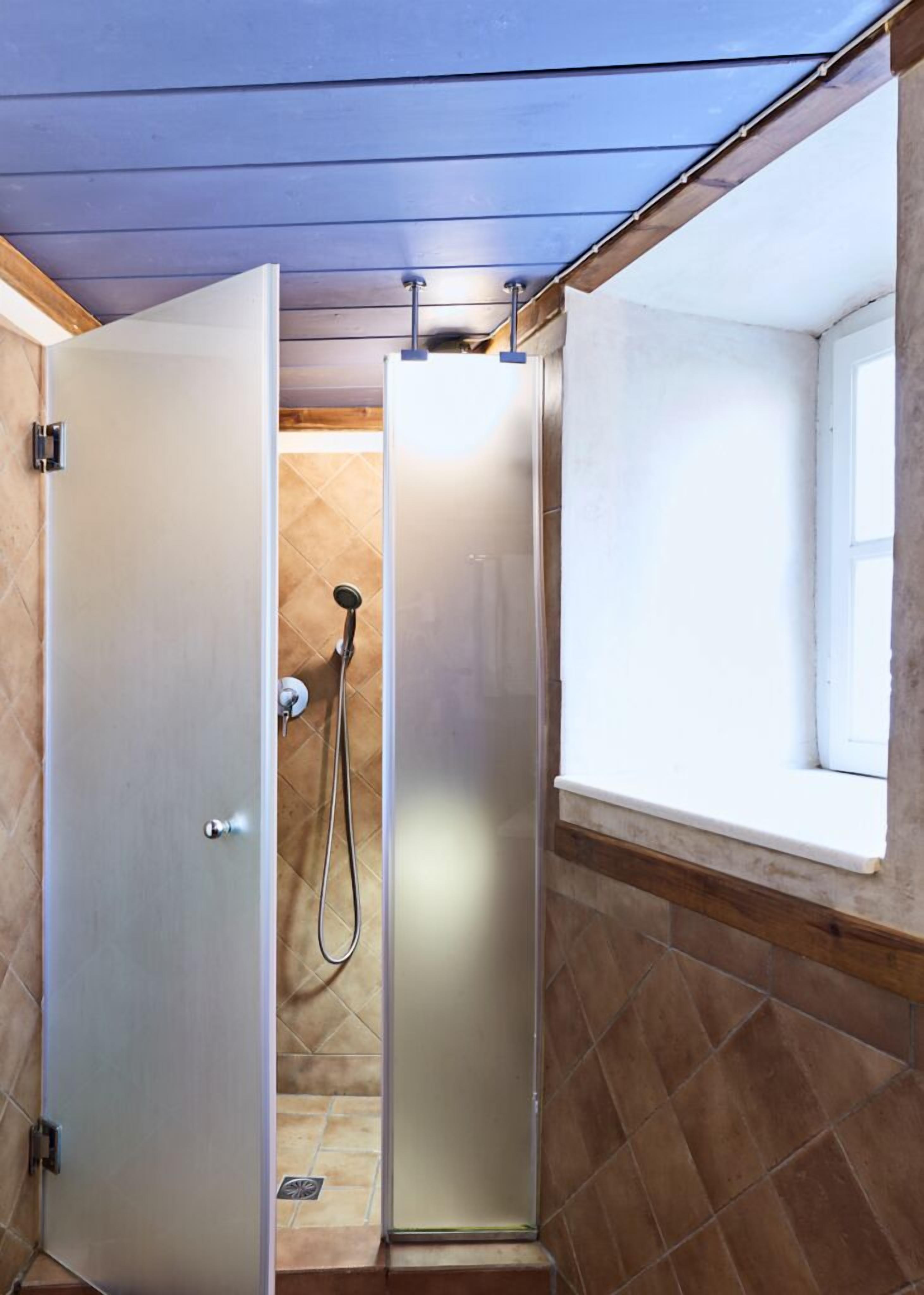 blue and yellow mezzanine studio | bathroom | shower, hair dryer, towels