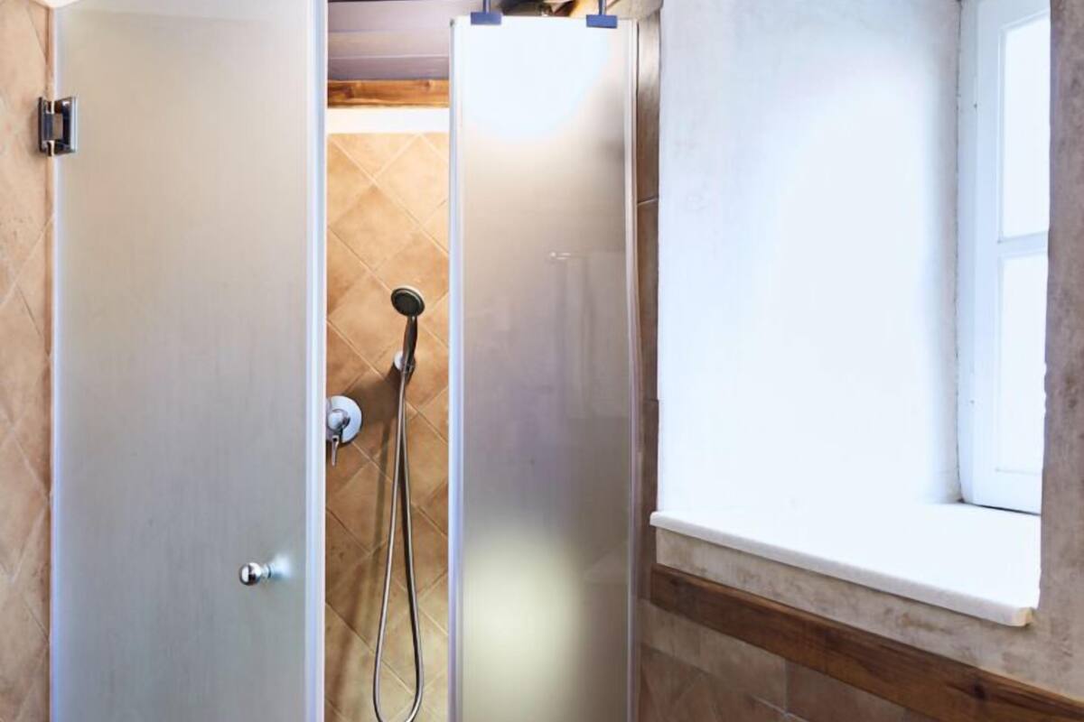 blue and yellow mezzanine studio | bathroom | shower, hair dryer, towels
