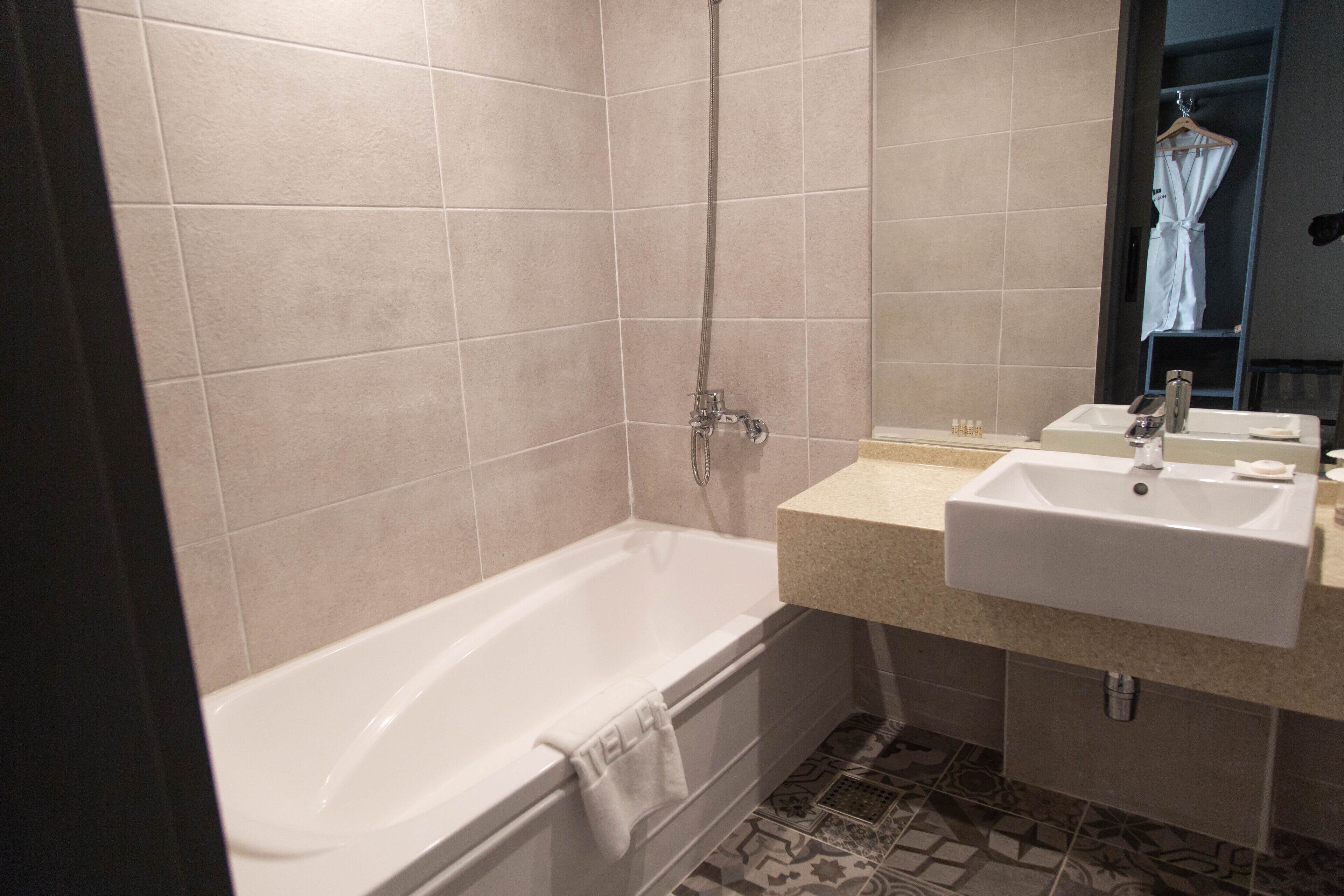 A bathroom with a bathtub, a sink, and a mirror.