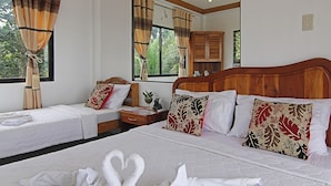 A hotel room with two single beds, a wooden headboard, a nightstand, a mirror, and a window with curtains. - Darcey Residences (Tagbilaran)