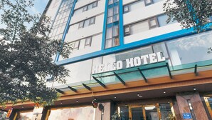 A multi-story hotel with a prominent "HELLO HOTEL" sign, large windows, and a modern facade. - Hello Hotel (Vo Cuong)