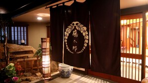 Un interior japonès tradicional amb tatami, un panell shoji, un fanal i un ramó decoratiu.