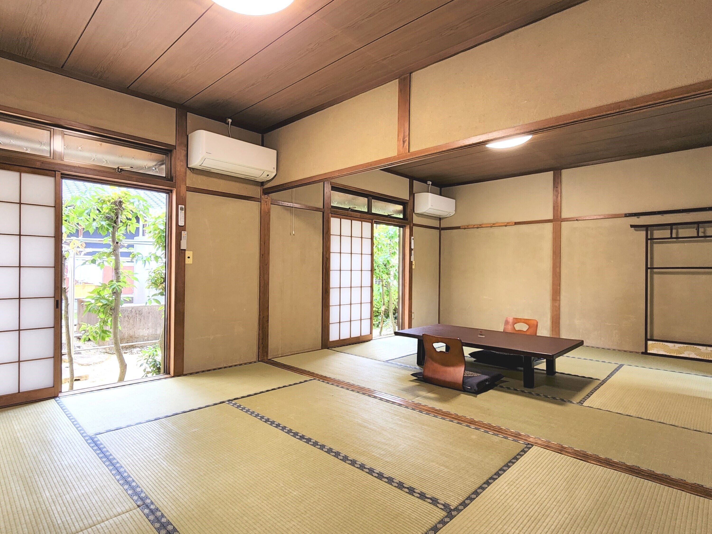 Een traditionele Japanse kamer met tatami vloerbedekking, een lage tafel en schuifdeuren.