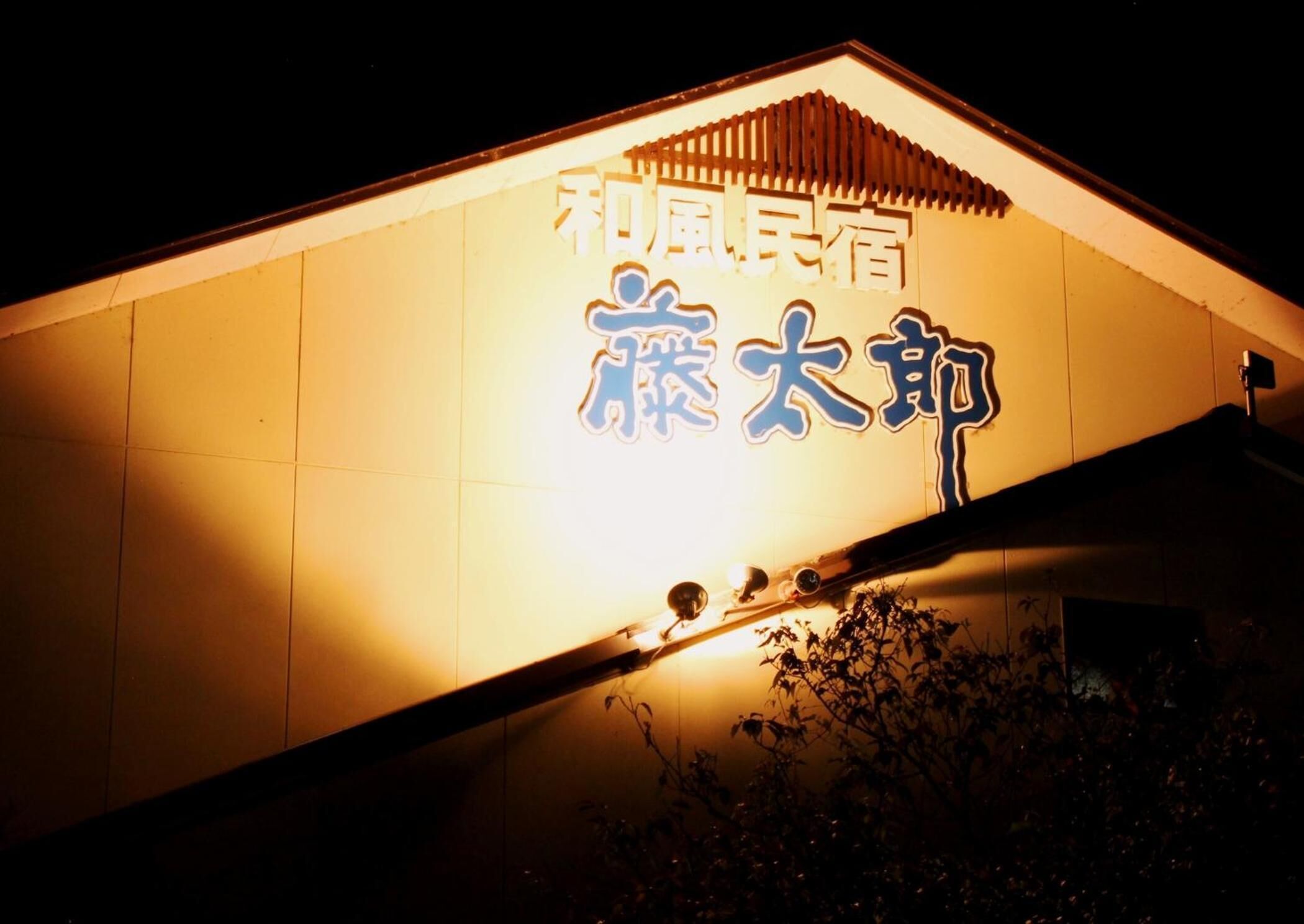 A building with illuminated signage in a foreign script, likely indicating a hotel or similar establishment.