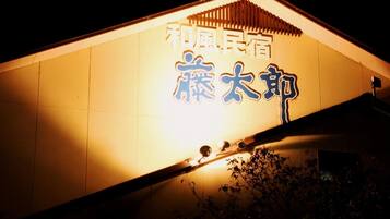 A building with illuminated signage in a foreign script, likely indicating a hotel or similar establishment.