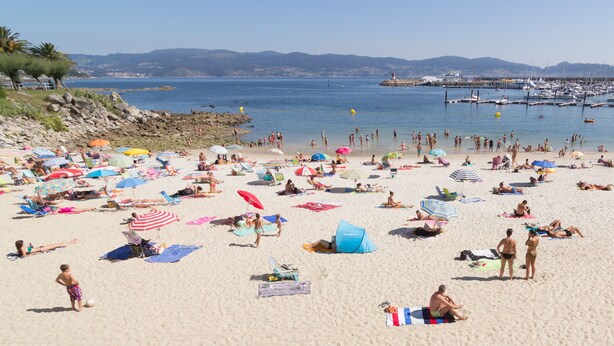 A crowded beach with numerous umbrellas and people relaxing. - Hotel Panadeiramar (Sanxenxo)