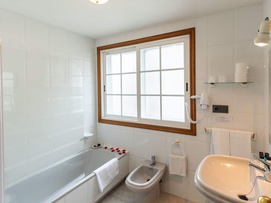 A modern bathroom with a bathtub, bidet, and sink.