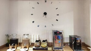 A coffee station with a clock on the wall, coffee dispensers, and a coffee machine. - Artch Inn (Luodong)
