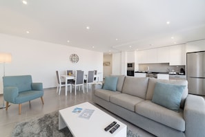 Un salon moderne comprenant un canapé, une table basse et un coin repas avec des chaises et une table.