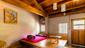 Interior de madera con un banco, un cojín rojo y un cuadro en la pared.