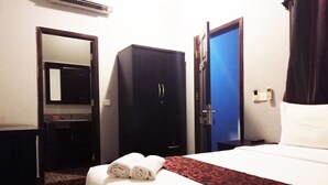 A hotel room with a bed, a wardrobe, a mirror, and a door. - Tonle Khmer Guesthouse (Phnom Penh)