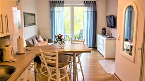 A cozy kitchen with a dining table, chairs, and a coffee maker.