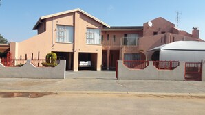 A two-story house with a garage, a reception area, and a satellite dish. - Diphororo Guest House (Moses Kotane)