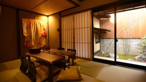 A traditional Japanese room with tatami flooring, a low table, and shoji screens. - Kyo-Machiya YululY (Kyoto)
