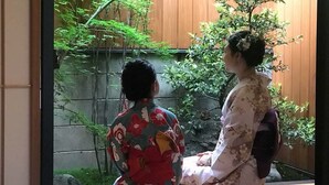 Two individuals in traditional attire sitting by a window overlooking a garden. - Kyo-Machiya YululY (Kyoto)