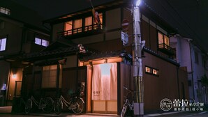 A traditional Japanese house with a wooden exterior, a visible entrance, and bicycles parked outside. - Kyo-Machiya YululY (Kyoto)