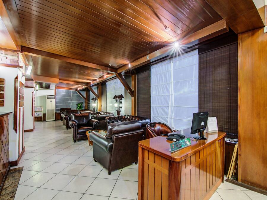 A spacious lobby with leather seating, a reception desk, and a large window.