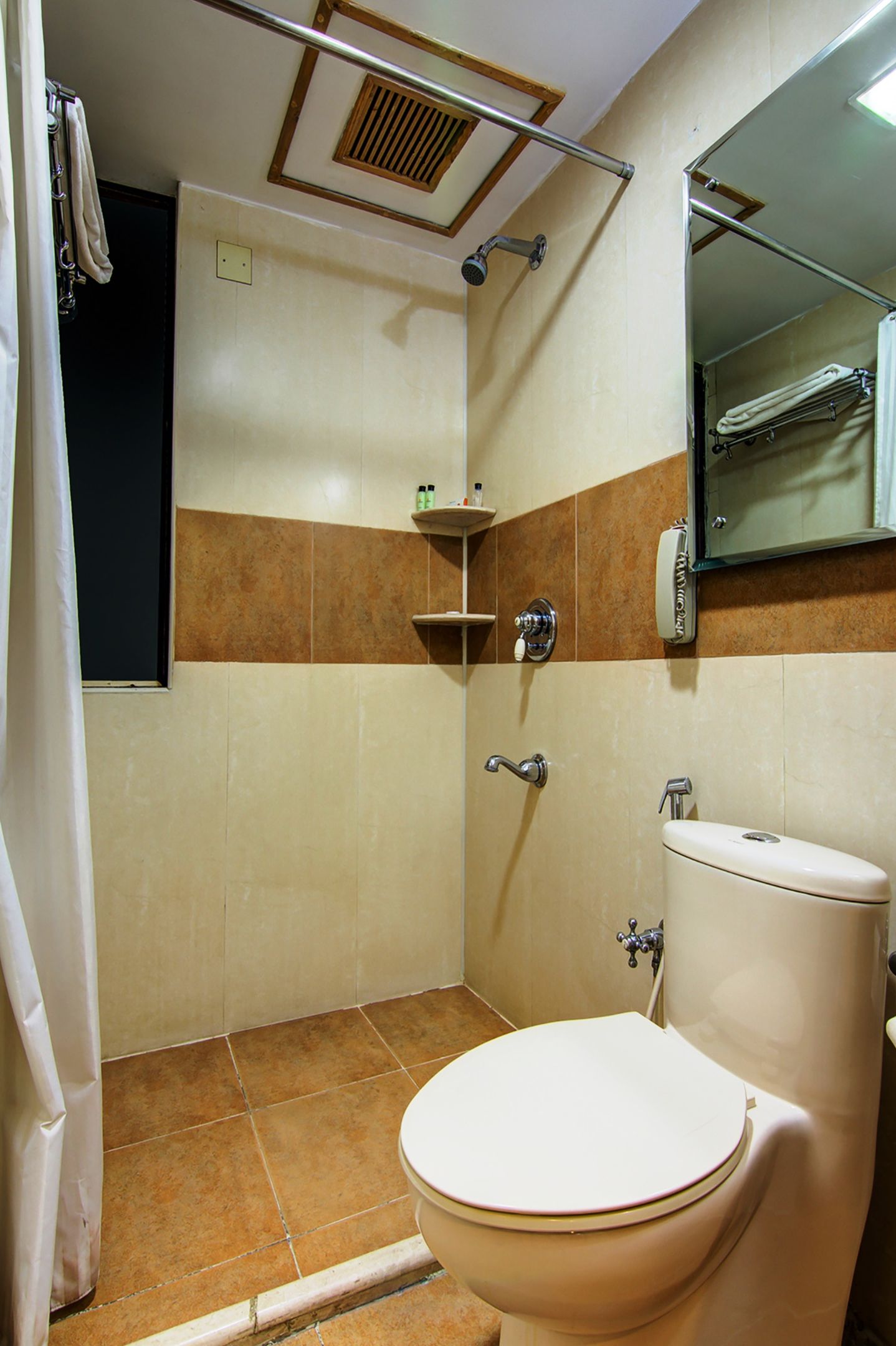 A bathroom with a shower, toilet, and a towel rack.