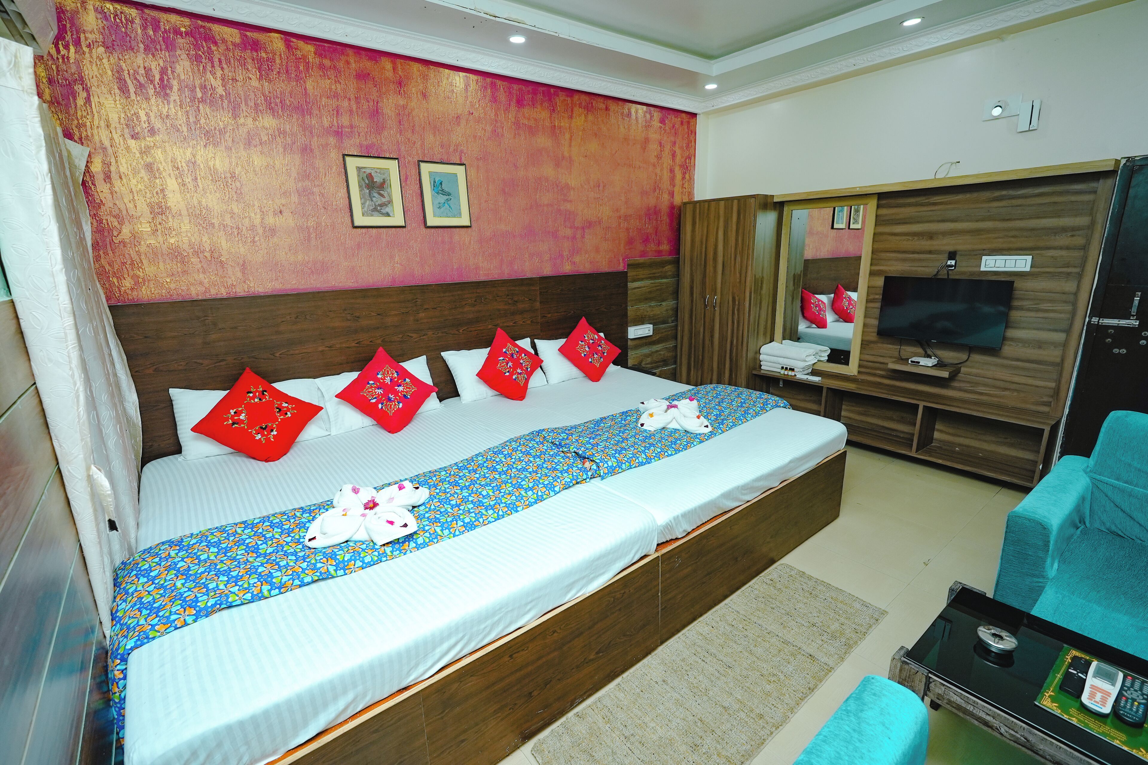 Una habitación de hotel con una cama grande, televisión, armario y zona de estar.