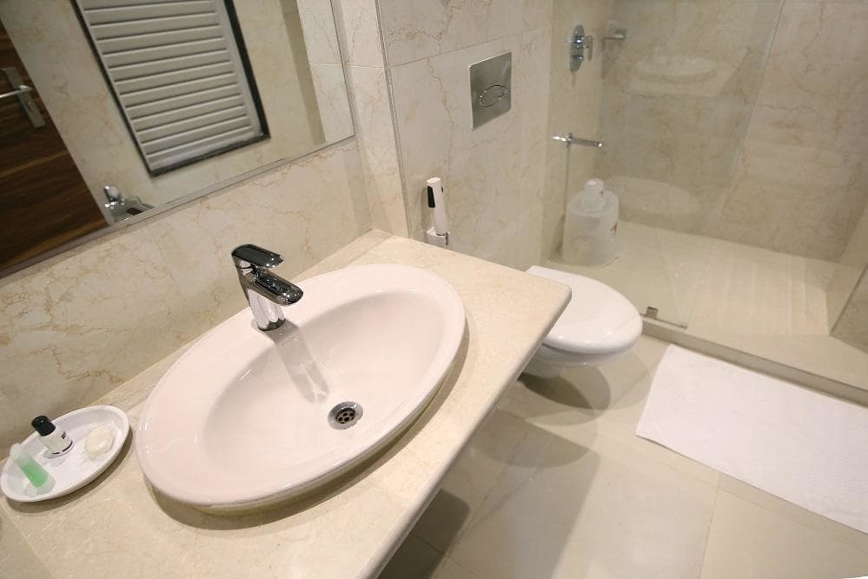 Un baño con lavamanos, inodoro y ducha blancos.