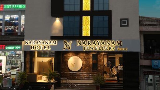 A modern hotel with a prominent vertical light strip and a sign for 'Narayanam Hotel'. - Hotel Narayanam (Kota)