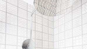 A shower with a modern, geometric tile pattern on the walls and a handheld showerhead. - The Cornish Arms (Tavistock)