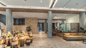 A spacious lobby with a high ceiling, large columns, and a central seating area. - Penh House Hotel (Phnom Penh)