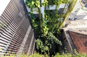 Un callejón estrecho con una cerca de madera a un lado y un edificio con tejado inclinado al otro.