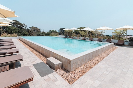 Una piscina al aire libre, sombrillas