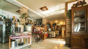A spacious bar area with a stone fireplace, a variety of bottles, and a wooden cabinet. - Albergo Ristorante Stella (Palestrina)