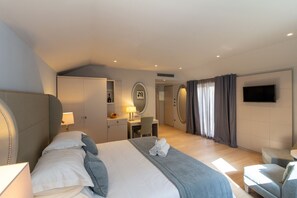 Une chambre d’hôtel moderne équipée d’un grand lit, d’un bureau, d’une télévision et d’une salle de bain.