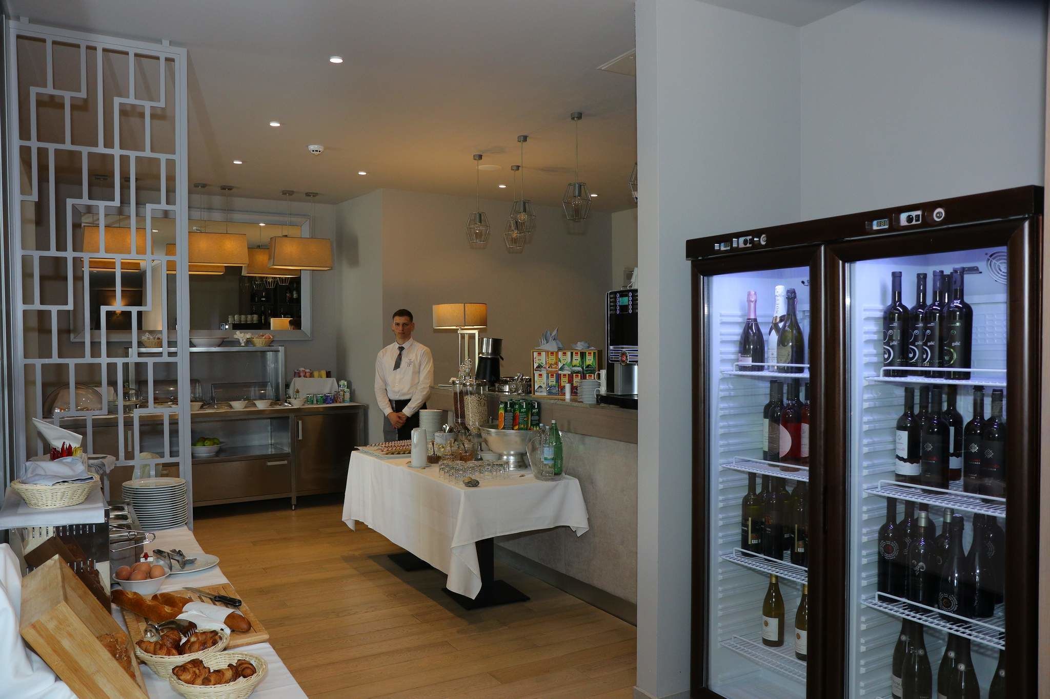 A buffet setup with various food items and a wine refrigerator.