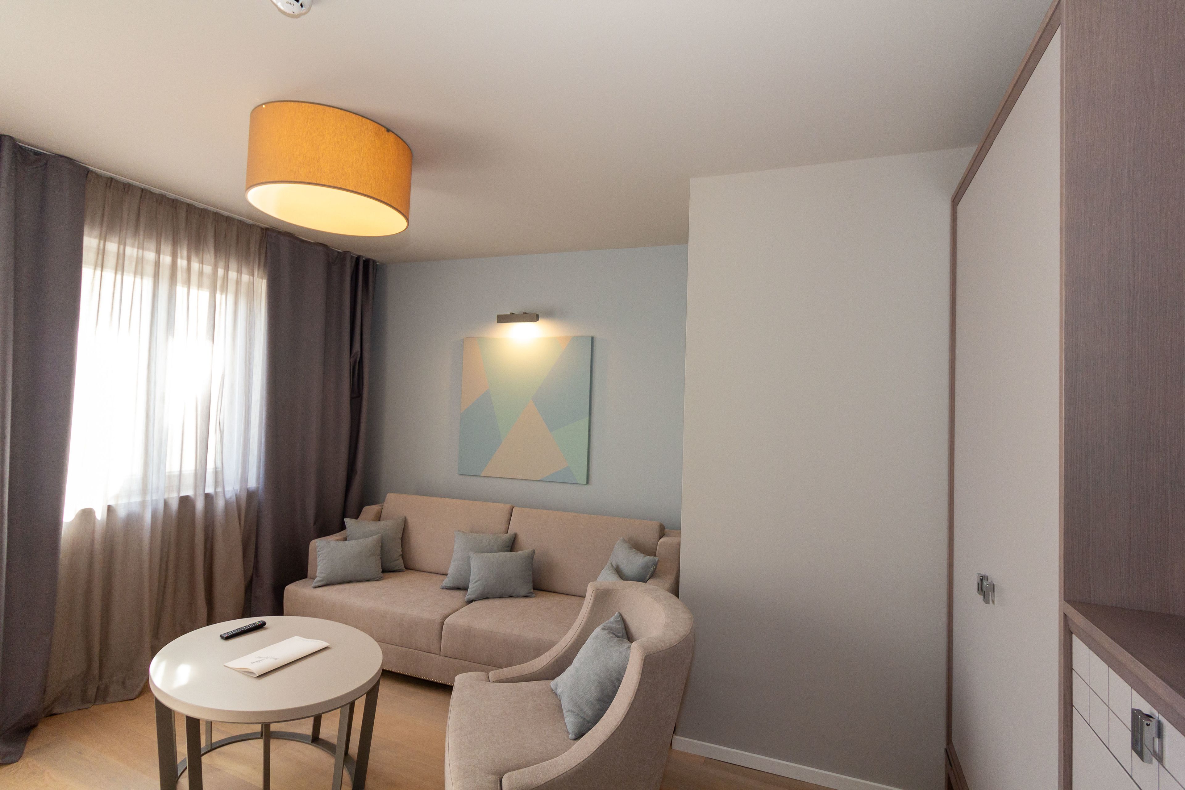 Un salon moderne avec un canapé, une petite table ronde et une lampe.
