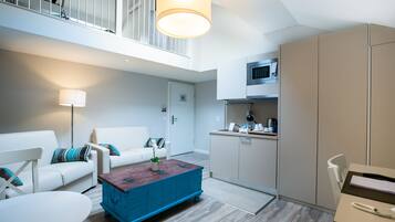 A modern apartment with a living room, a dining area, and a kitchenette.