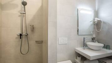 Ein modernes Badezimmer mit Dusche, Waschbecken und Toilette.