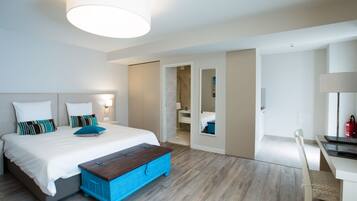 Een moderne hotelkamer met een groot bed, een bureau en een badkamer zichtbaar door een geopende deur.