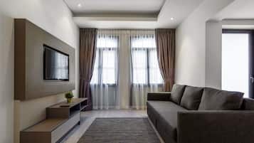 Suite Deluxe | Área de sala de estar | Televisión de pantalla plana y chimenea
