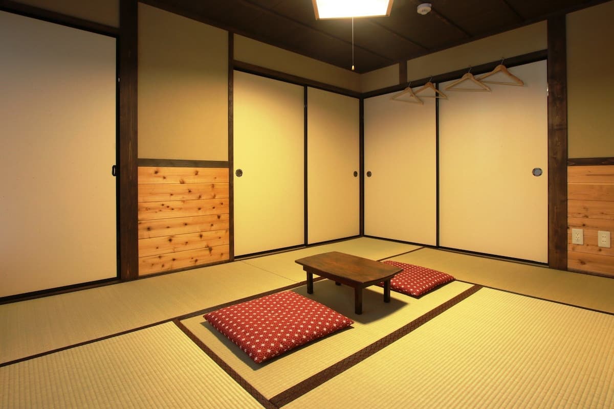 A traditional Japanese room with tatami flooring, a low wooden table, and shoji screens.