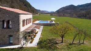 A stone building with a pool and a vineyard. - Les Planes del Grau (Sant Joan de Les Abadesses)