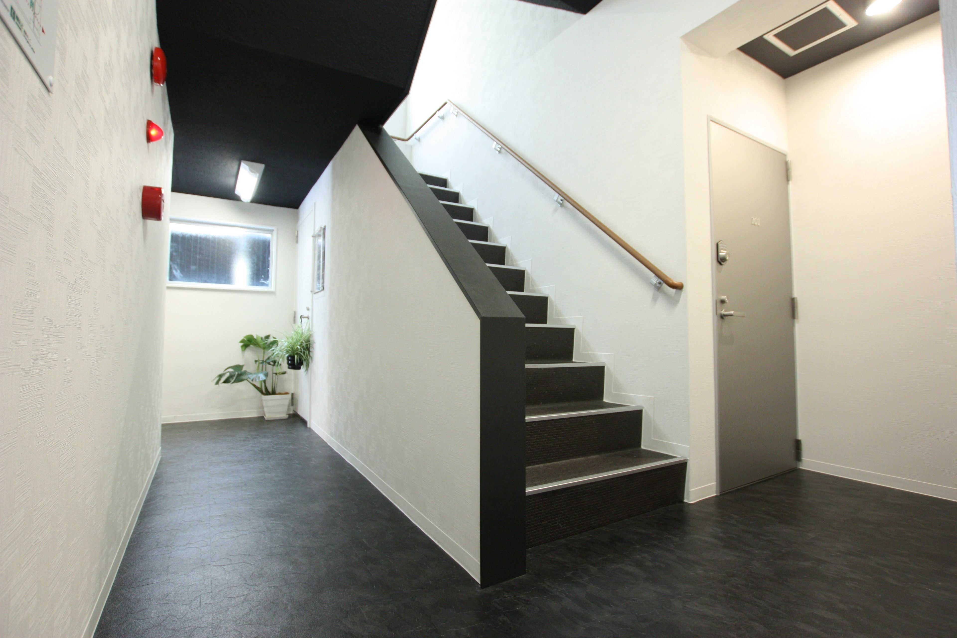 A modern interior with a staircase, a door, and a window.