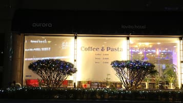 A Coffee & Pasta restaurant with a sign listing prices for coffee, pasta, and beer.