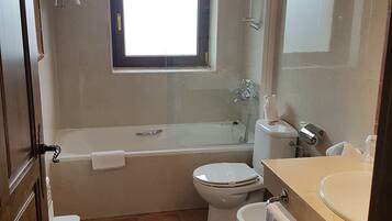 A bathroom with a bathtub, toilet, and sink.