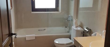 Une salle de bain avec une baignoire, des toilettes et un lavabo.