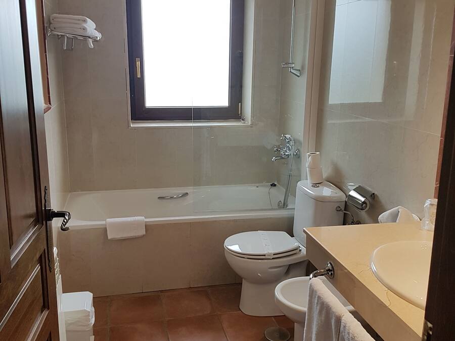 A bathroom with a bathtub, toilet, and sink.