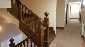 Una escalera de madera con barandilla y balaustres que conduce a un piso superior.