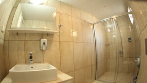 A bathroom with a sink, mirror, and shower. - Queenaba Beach (Erdemli)