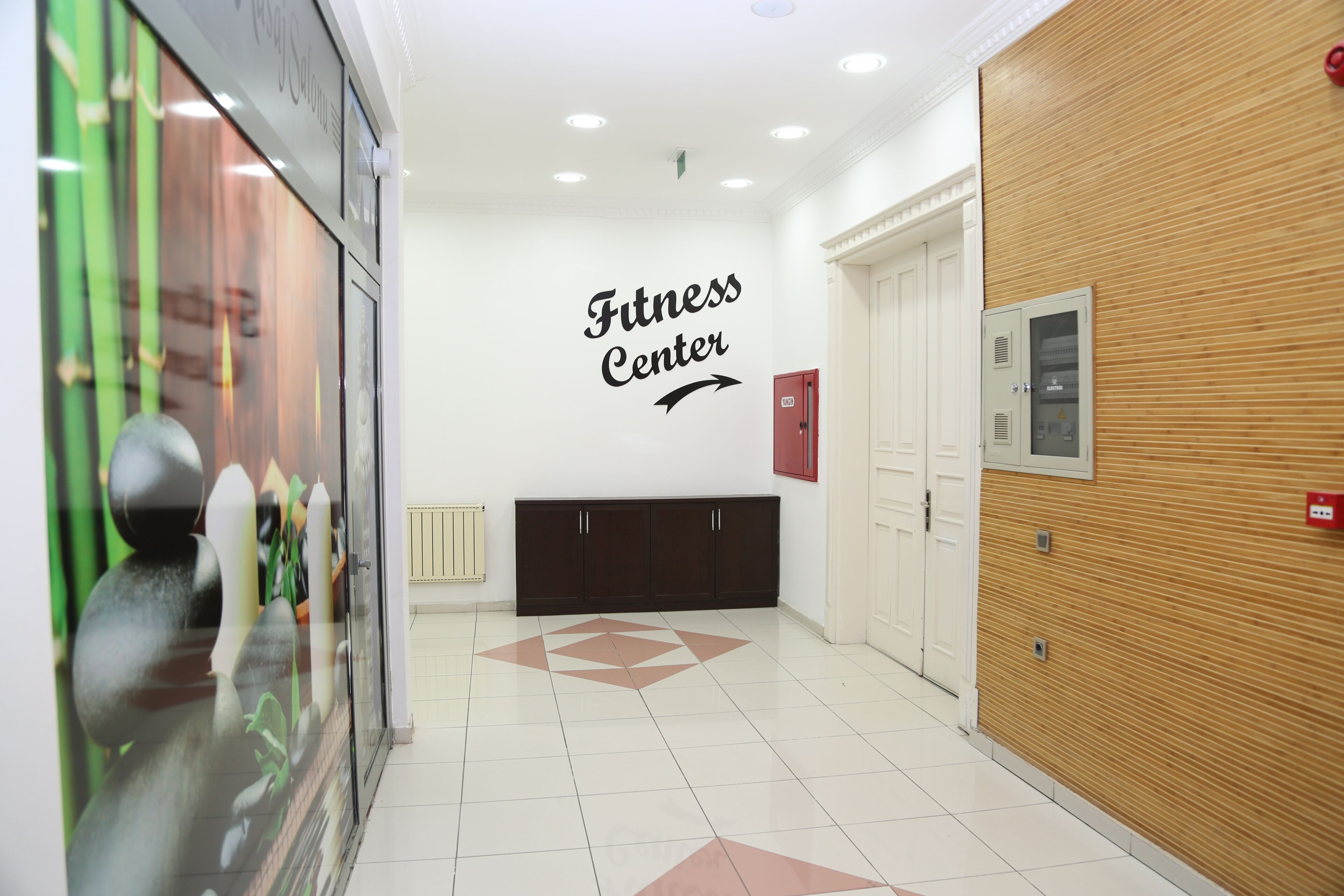 A fitness center with a sign, a reception area, and a wooden wall.